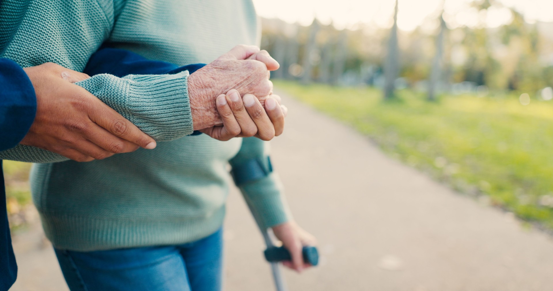 Park, walking stick and caregiver with senior woman for assisted living, support and care in nature. Retirement, help and hands of elderly person with disability for wellness, health and recovery