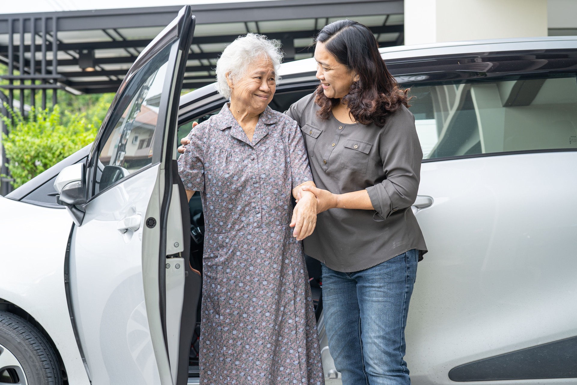 Help and support asian senior or elderly old lady woman patient sitting on wheelchair prepare get to her car, healthy strong medical concept.